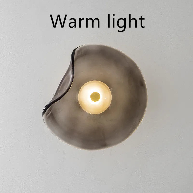 Round glass bedside wall lamp in cognac, light purple, or smoky grey colour.
