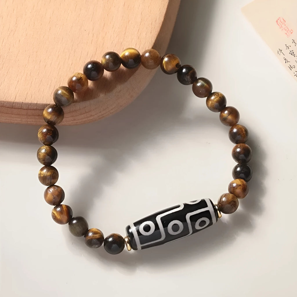 Single Tigereye Dzi bead Buddha rosary bracelet on wrist, showing simple ethnic design.