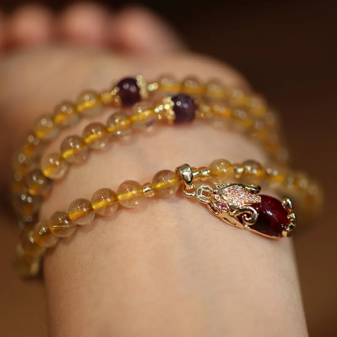 Handmade gold and ruby quartz Chinese bracelet with three circles and hanging chopstick detailing