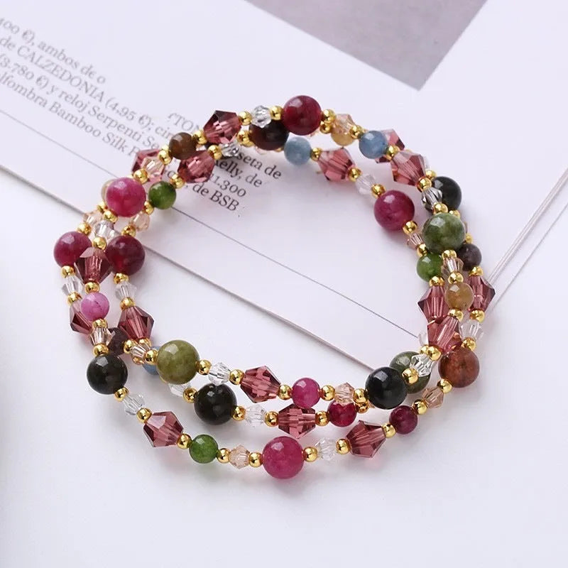 Women's adjustable three-ring bracelet with colourful tourmaline, strawberry quartz, and amethyst crystals on a cord.