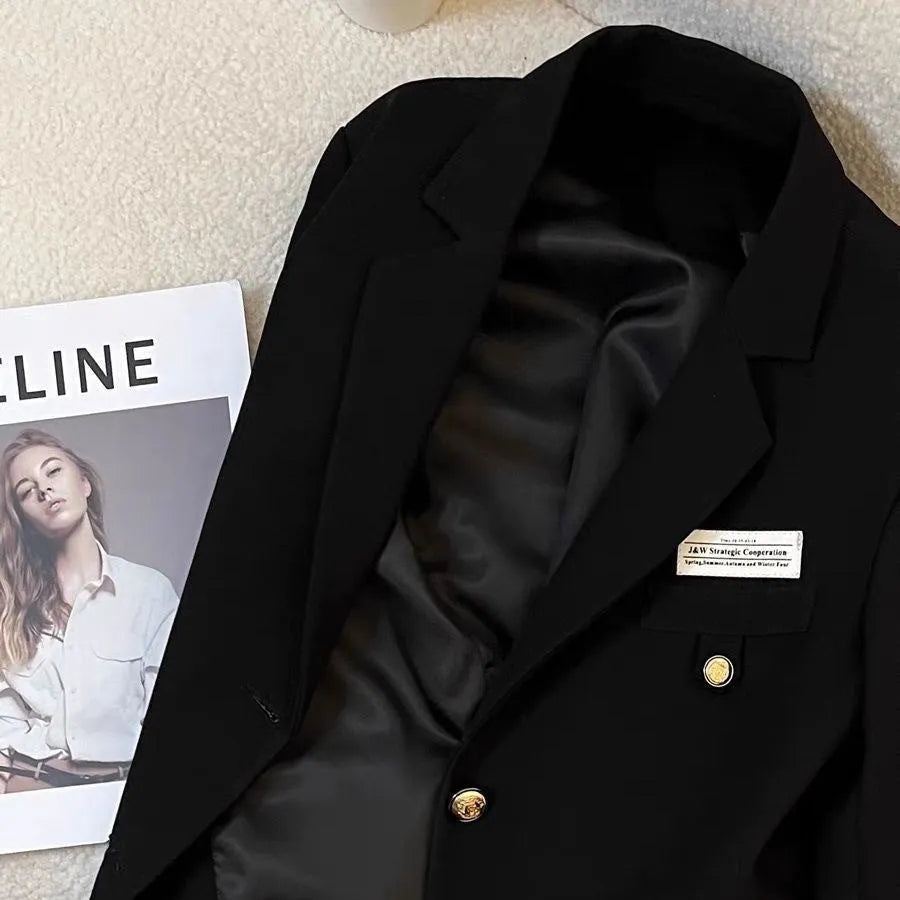 Black women's loose-fit short suit coat with long sleeves and pockets.