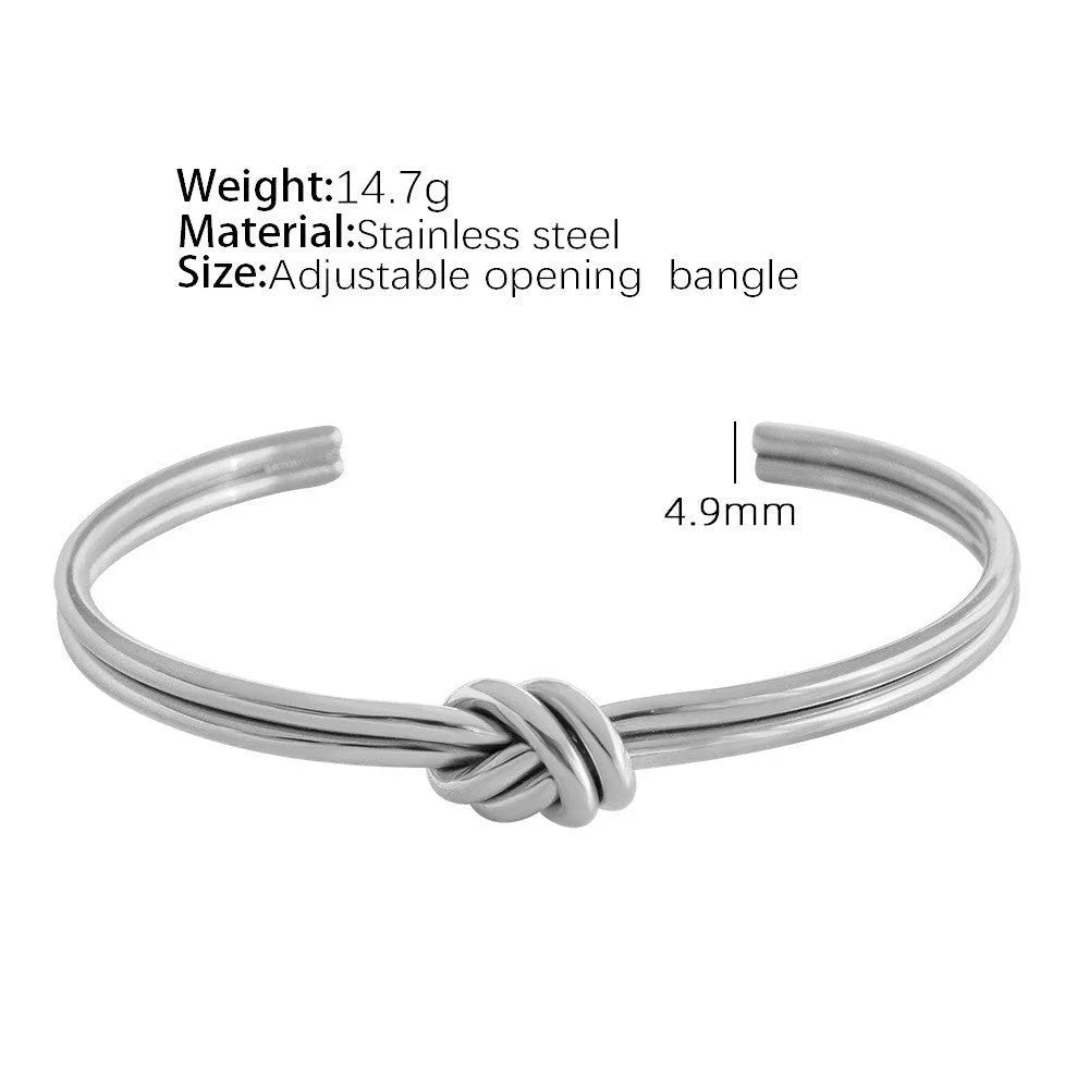Women's open C-shape knotted double-layer bracelet in gold or silver plating on a wrist.
