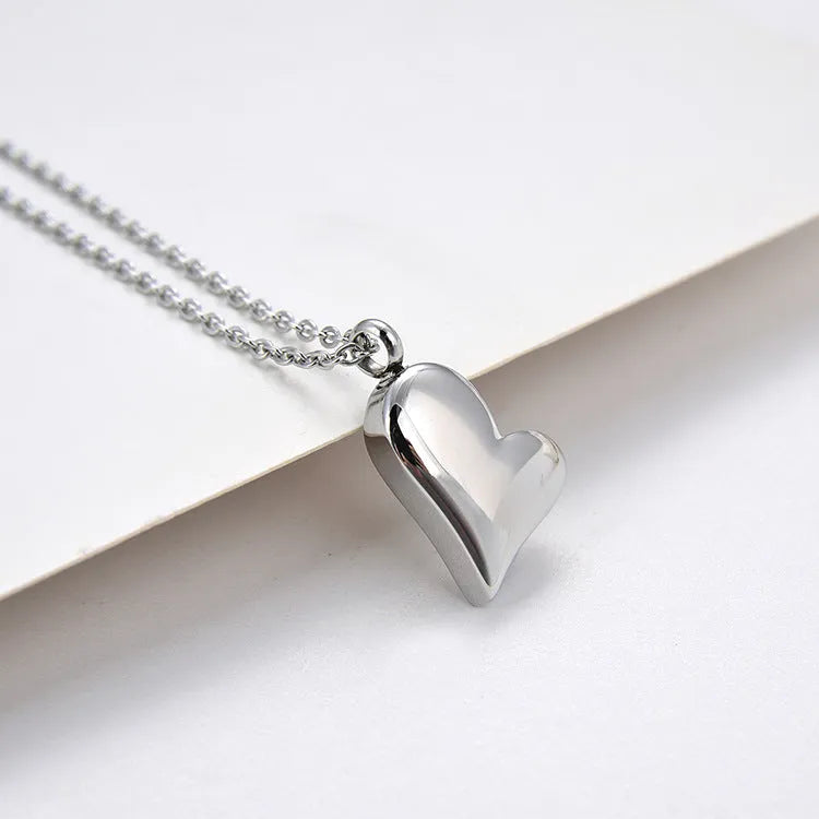 Silver curved peach heart pendant on stainless steel necklace chain with extension