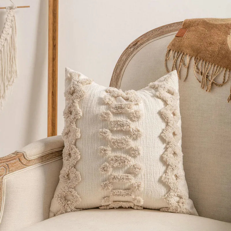 Knitted striped cushion cover with tassel trim in 45x45cm size on a sofa.