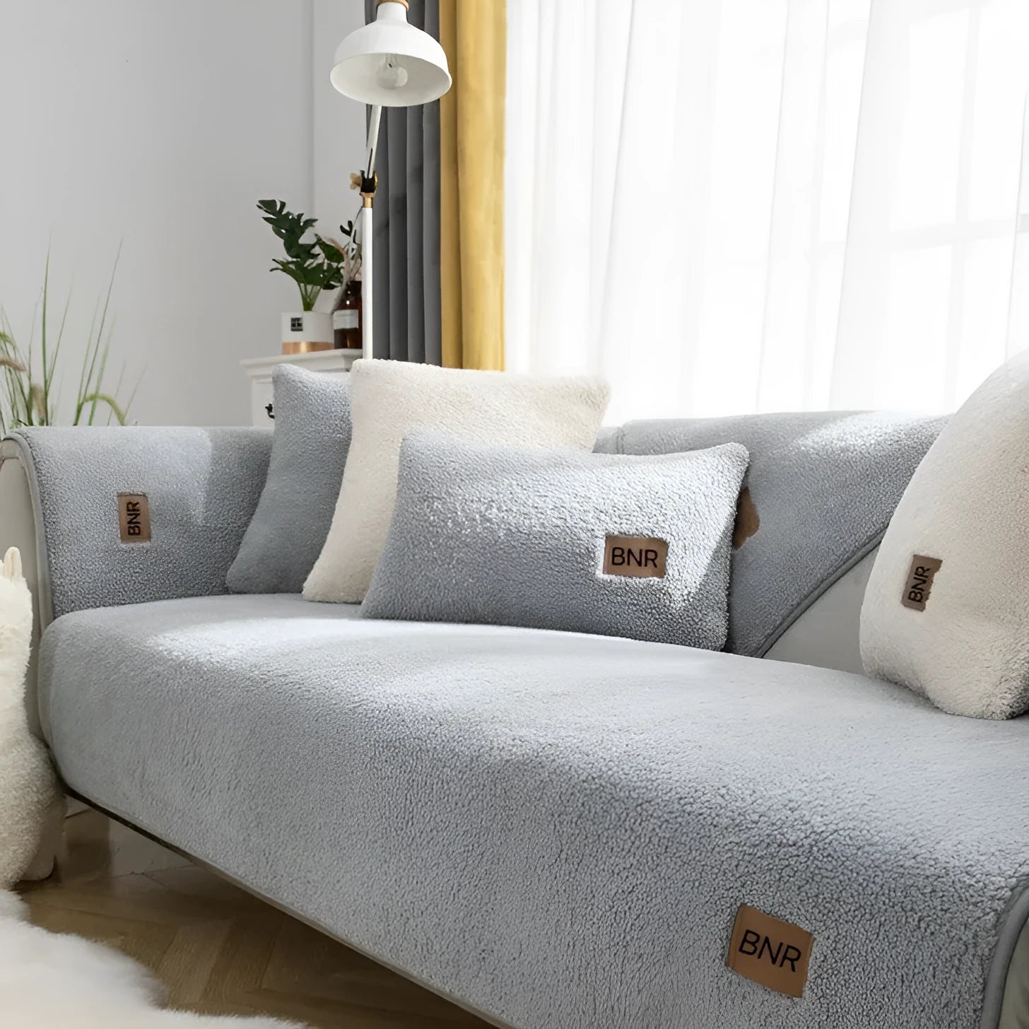 Lambswool solid colour sofa cover in blue on a grey sofa