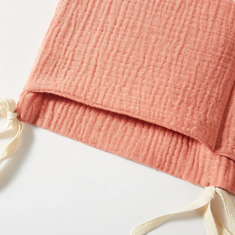 Cotton double layer baby bedside buggy bag in camel colour with tie straps attached to a pram handle
