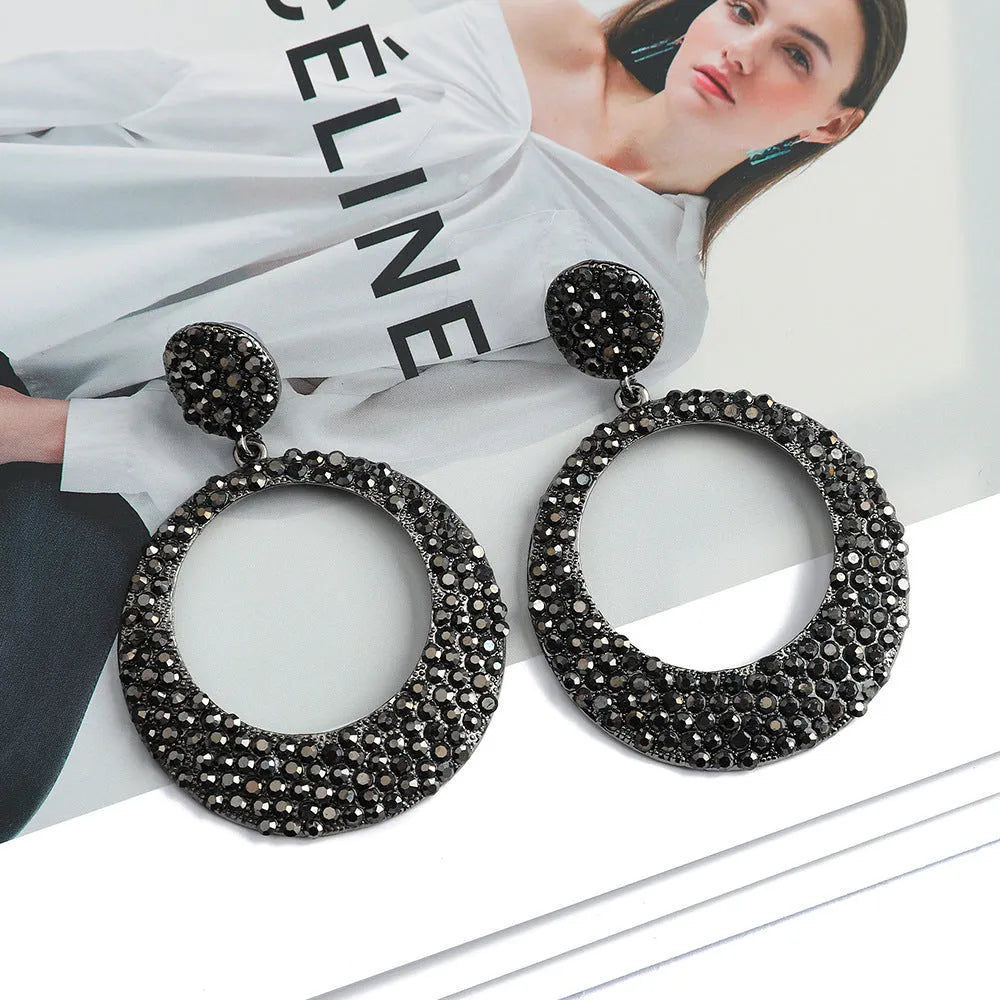 Large round pendant earrings with cartoon design and diamante accents on alloy metal