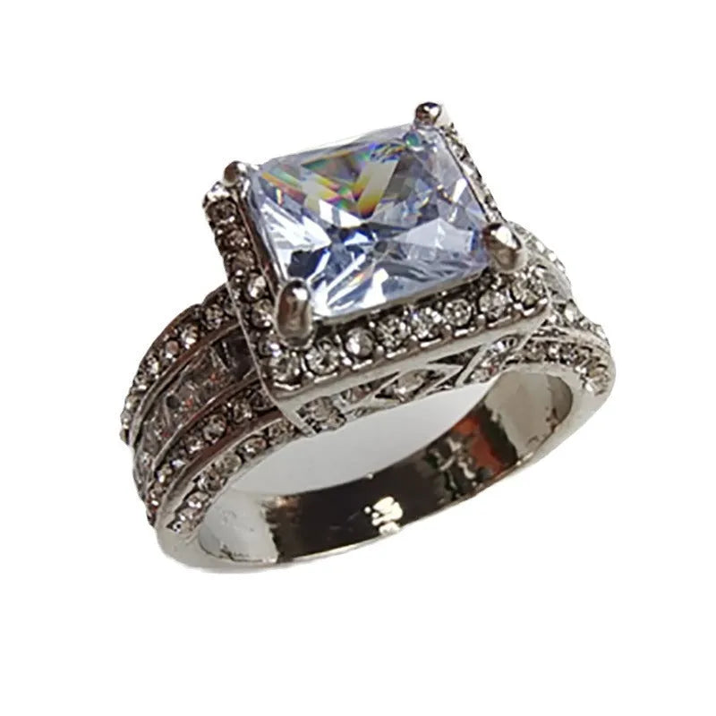 Geometric silver-toned women's fashion ring in gold or white colour on a grey background.