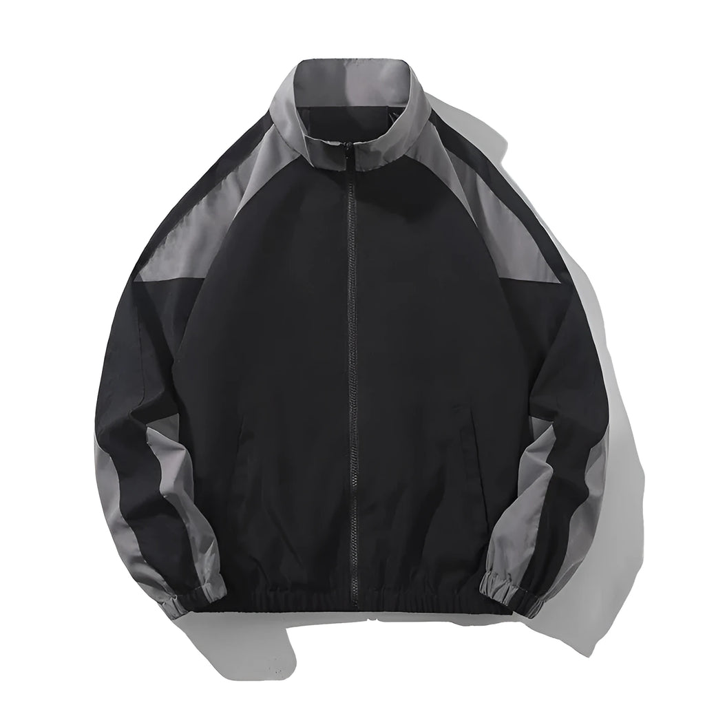 Man wearing a black casual jacket with contrast stitching and side pockets.
