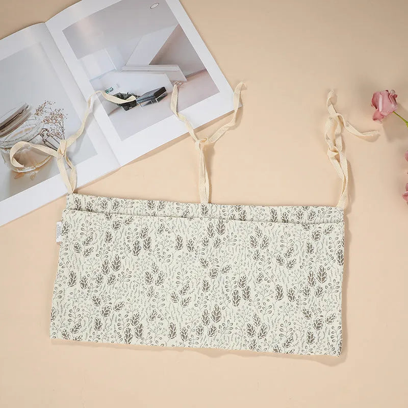 Cotton double layer baby bedside buggy bag in camel colour with tie straps attached to a pram handle