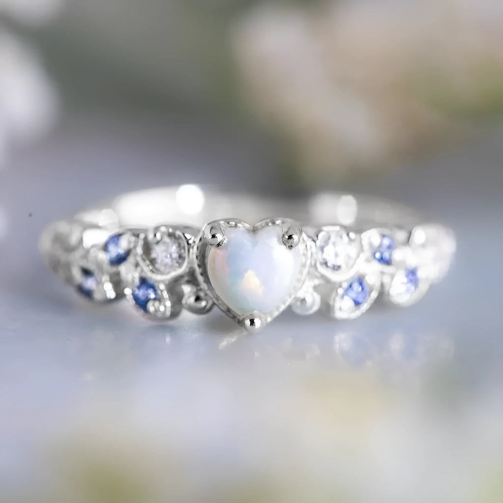 White electroplated alloy heart ring with floral opal ocean design on a jewellery display
