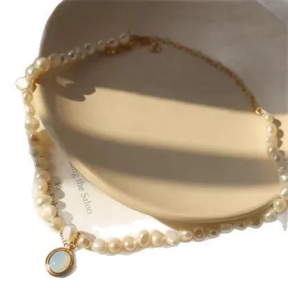 Gold baroque pearl clavicle chain necklace with copper pendant on a woman's collarbone