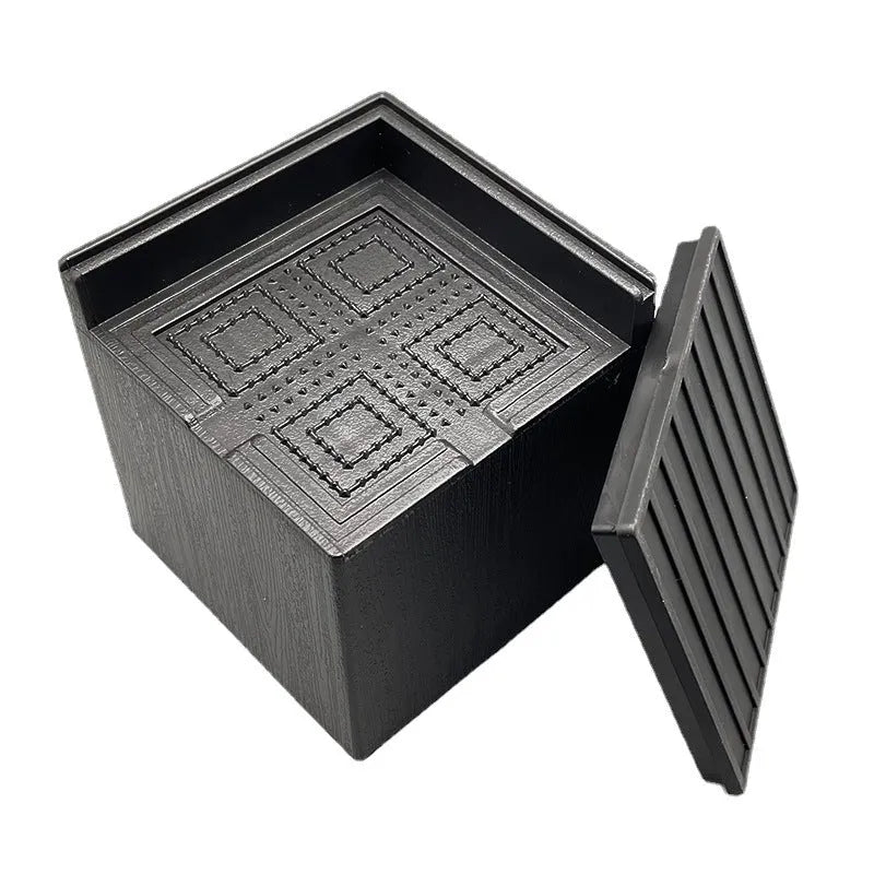 Four black thickened plastic furniture foot height increasing mats on a white background