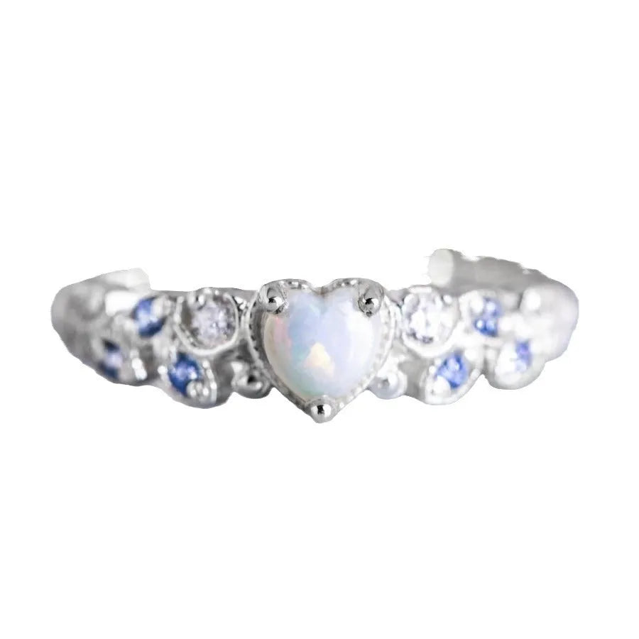 White electroplated alloy heart ring with floral opal ocean design on a jewellery display
