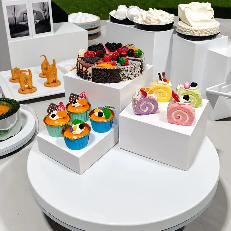 Six identical white plastic cube dessert display stands arranged together.
