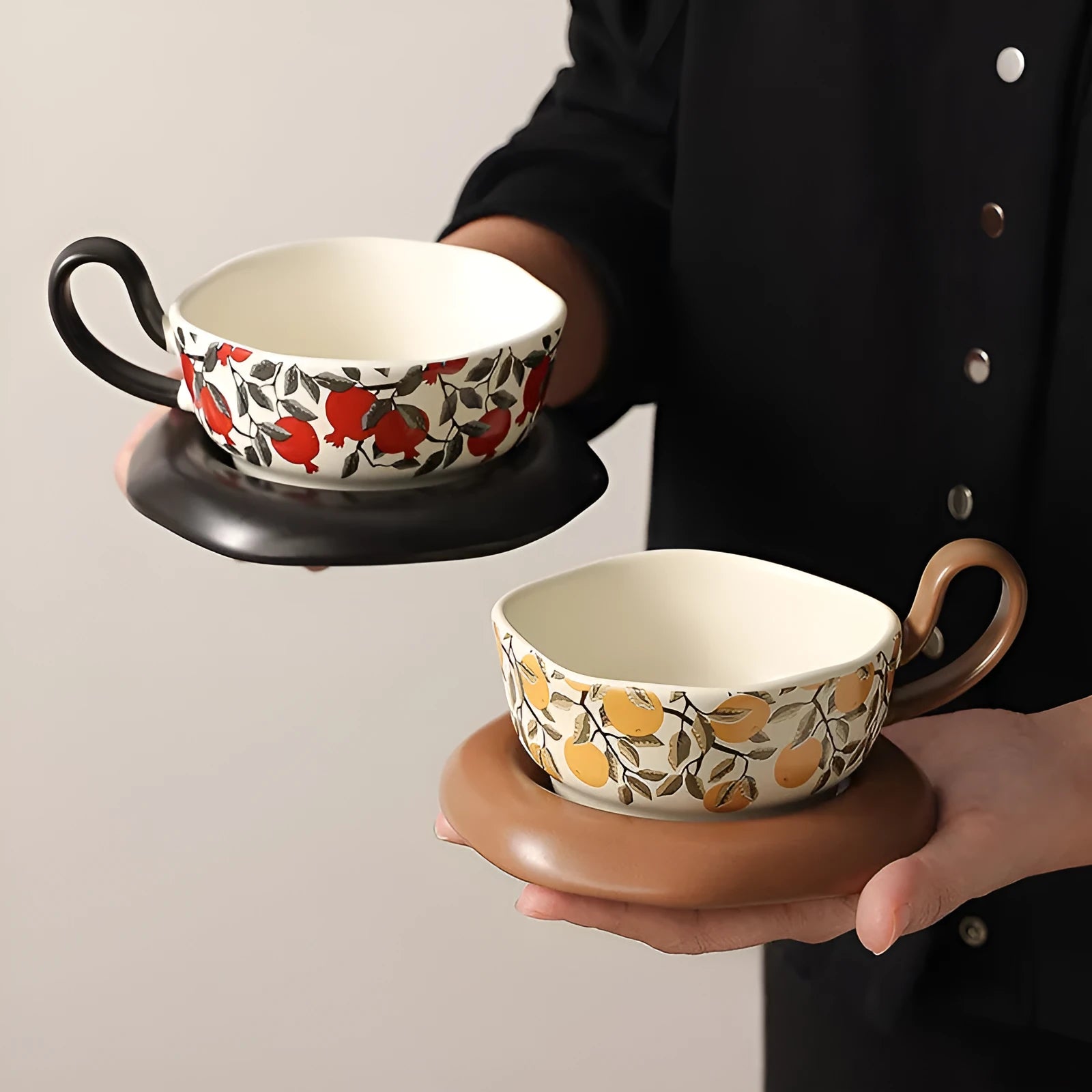 Antique ceramic coffee cup and saucer set in black or orange with medieval fruit design