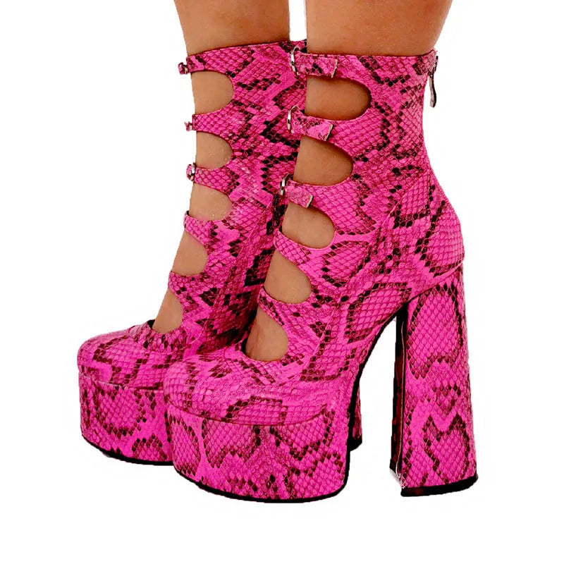 Black patent leather women's ankle boots with a platform, thick block heel, and a serpentine buckle strap around the ankle.
