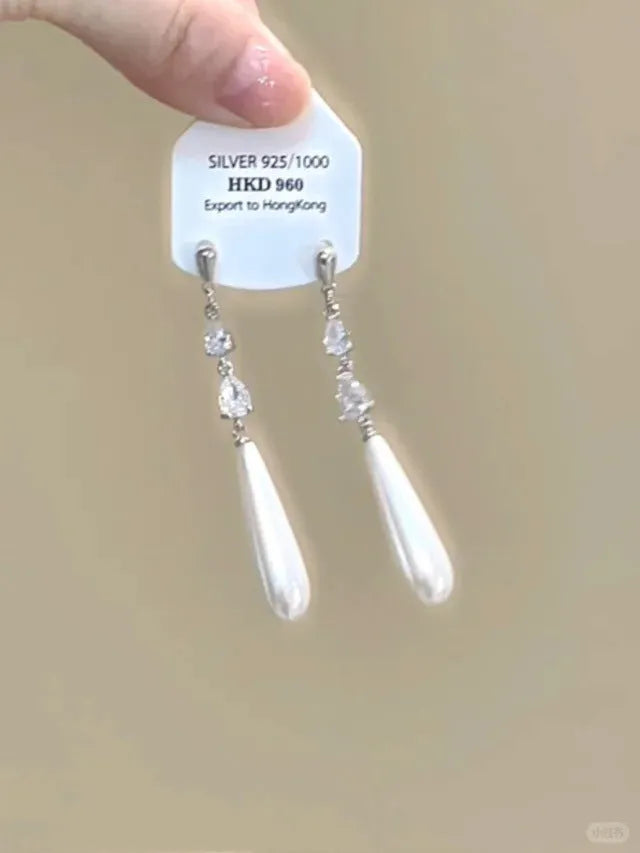 Geometric heart-shaped women's earrings with rhinestones and a silver tassel, shown on a white background.