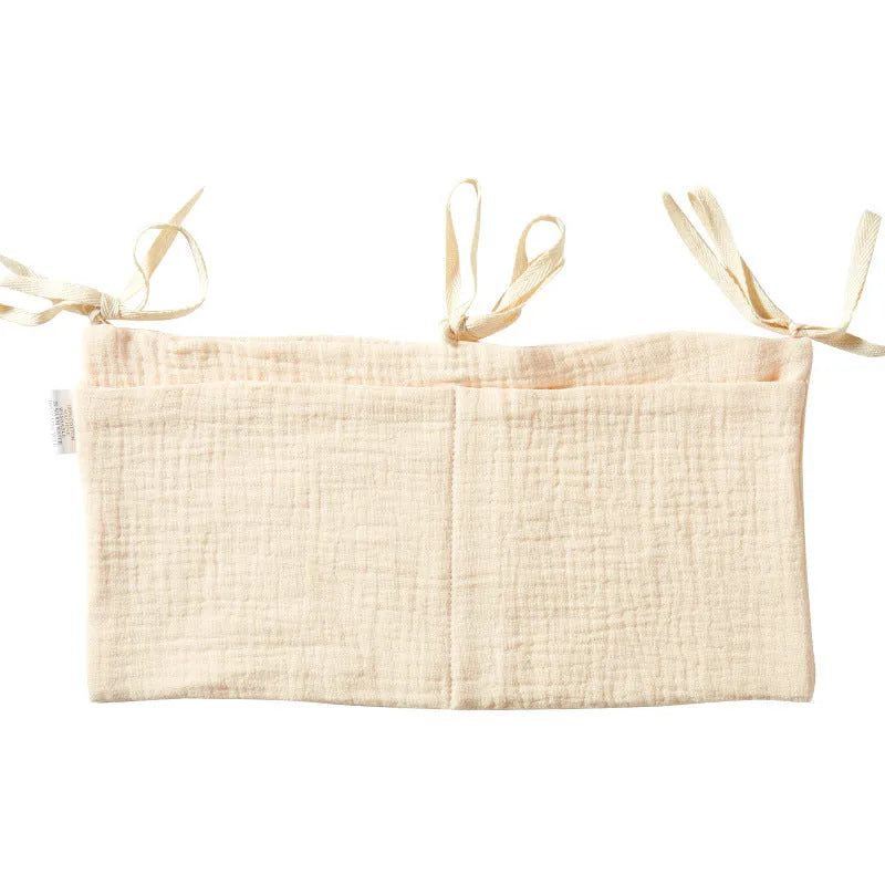 Cotton double layer baby bedside buggy bag in camel colour with tie straps attached to a pram handle
