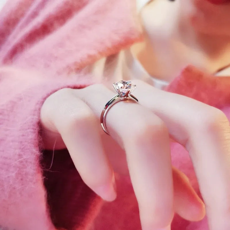 White gold plated six-claw zircon women's ring with geometric shape on a finger.