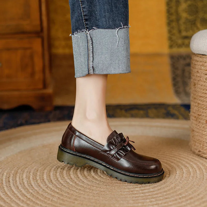 Women's black leather shoes with round toe and chunky flat heel on white background