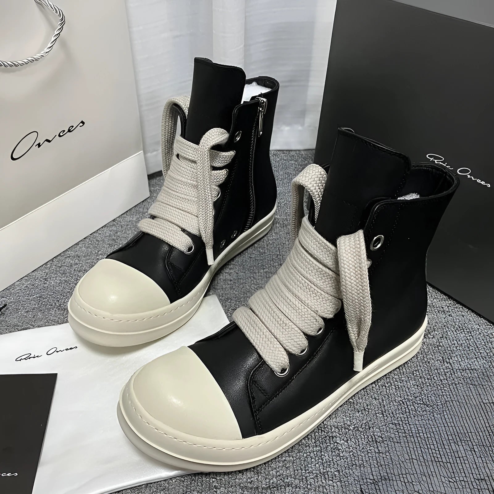 Black high-top leather sneakers with side zipper and platform sole on a white background