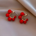 Red bell-shaped alloy drop earrings for women on a white background.