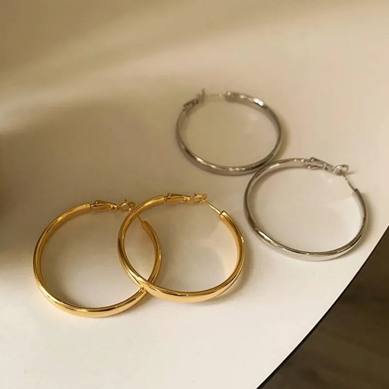 A pair of circular open-ring metal earrings in a gold or silver finish, measuring 40mm.