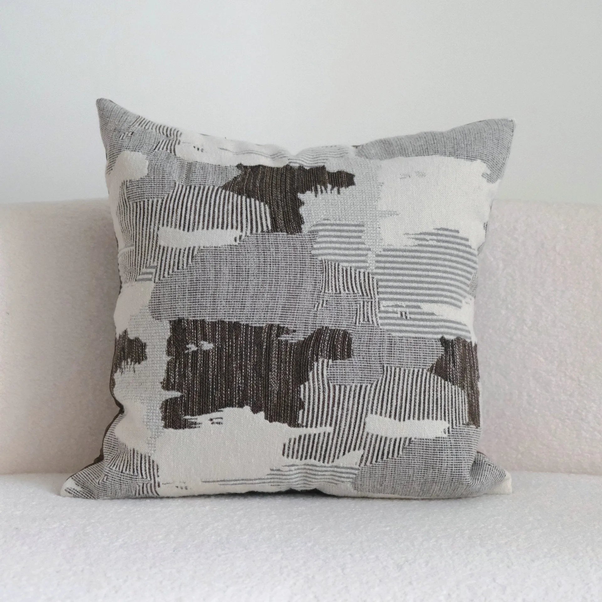 Coffee brown striped mid-century sofa cushion in Chinese classical style on a grey sofa.