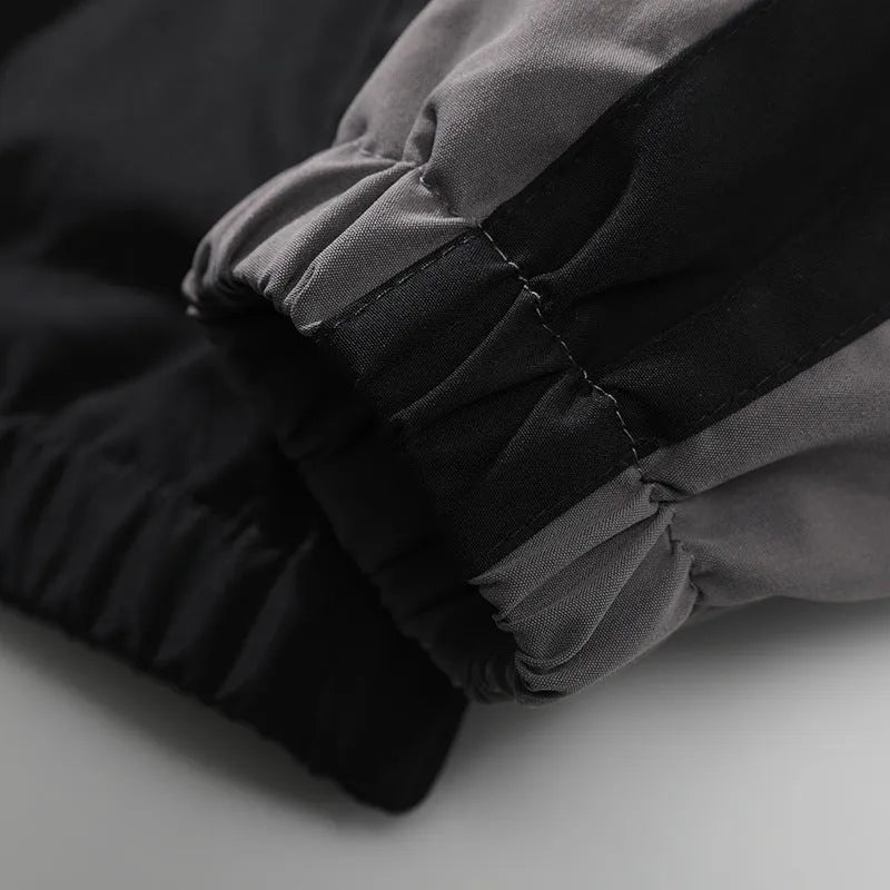 Man wearing a black casual jacket with contrast stitching and side pockets.