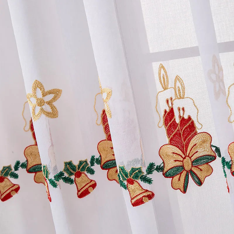 Pair of white Christmas curtains with detailed embroidered red and green snowflake design, showing texture and semi-sunshade fabric.