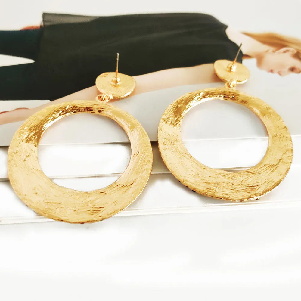 Large round pendant earrings with cartoon design and diamante accents on alloy metal