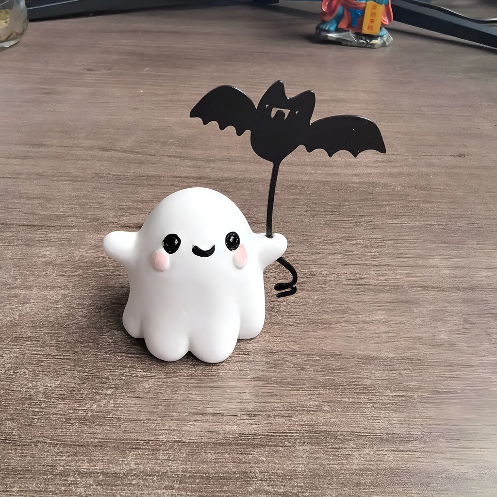 Small resin statue of a ghost walking a dog and holding a bat, a mini Halloween ornament.
