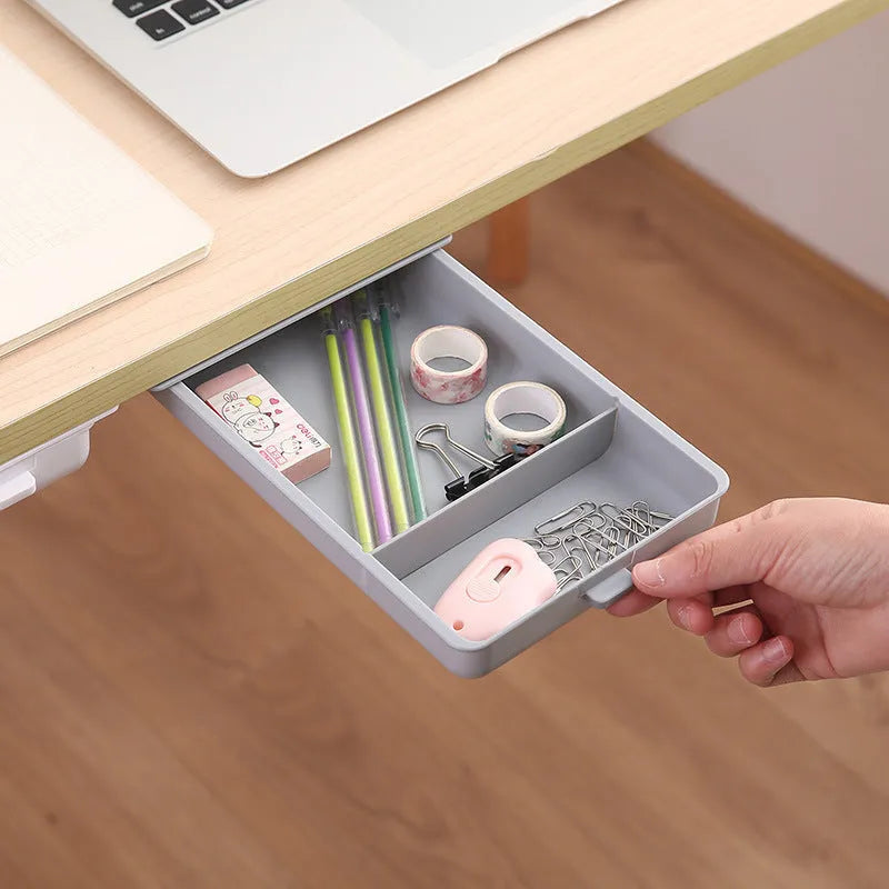 Small white plastic storage box with a grid pattern, shown adhered underneath a wooden table.