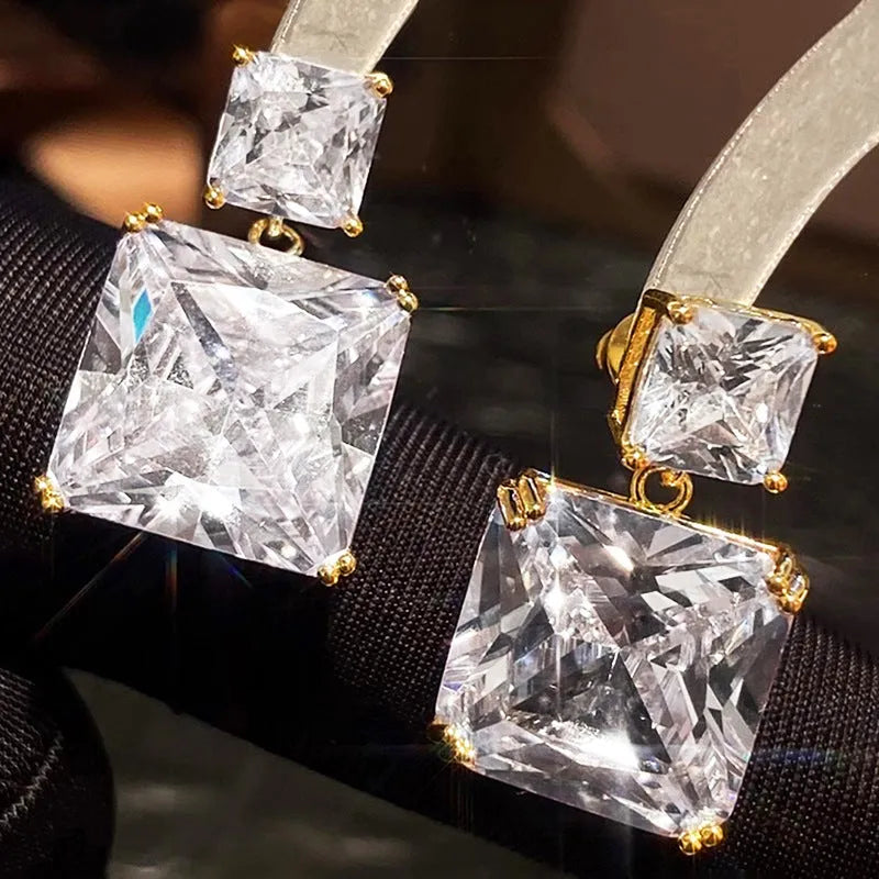 A pair of copper geometric square earrings for women, shown in white gold and golden colour options.