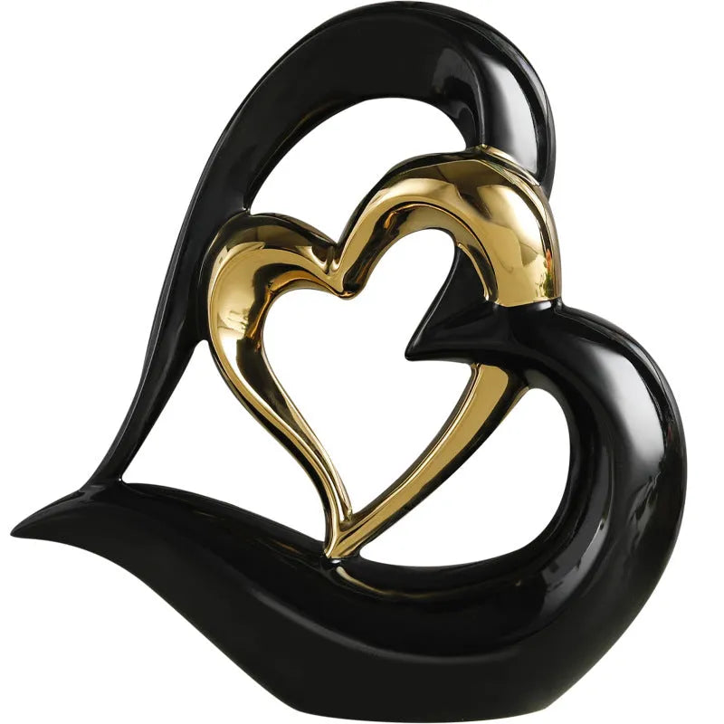 Modern white porcelain heart ornament in a metallic finish, showing its geometric shape on a table.