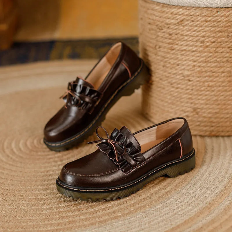 Women's black leather shoes with round toe and chunky flat heel on white background