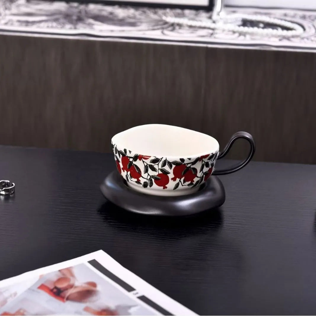 Antique ceramic coffee cup and saucer set in black or orange with medieval fruit design