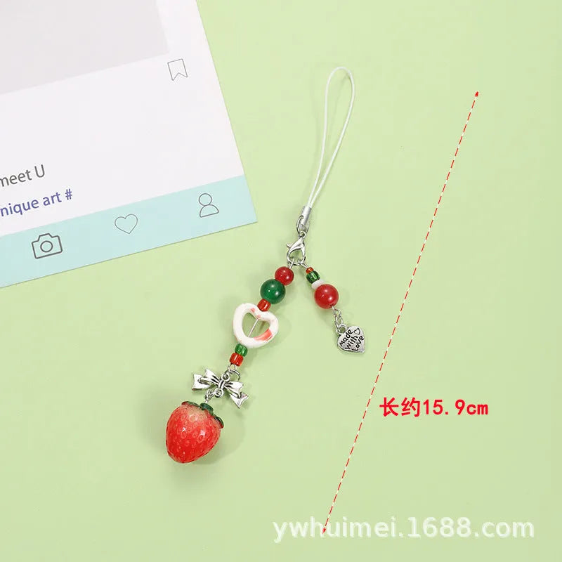 Plastic resin fruit phone charm keychain with strawberry design on white rope cord