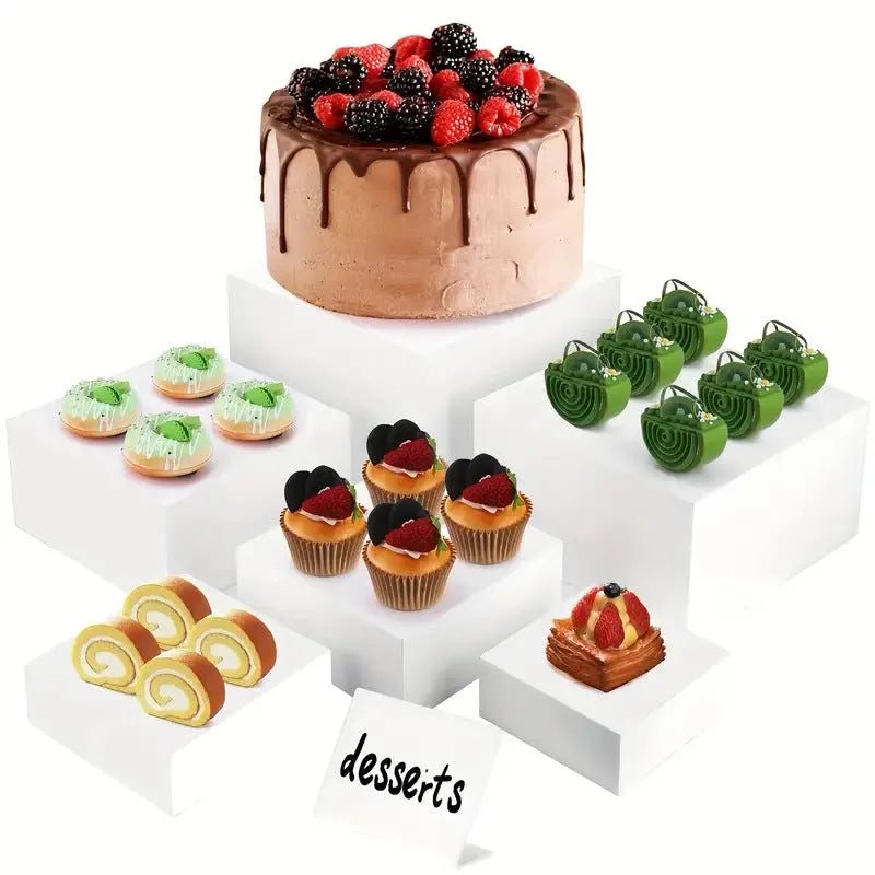 Six identical white plastic cube dessert display stands arranged together.