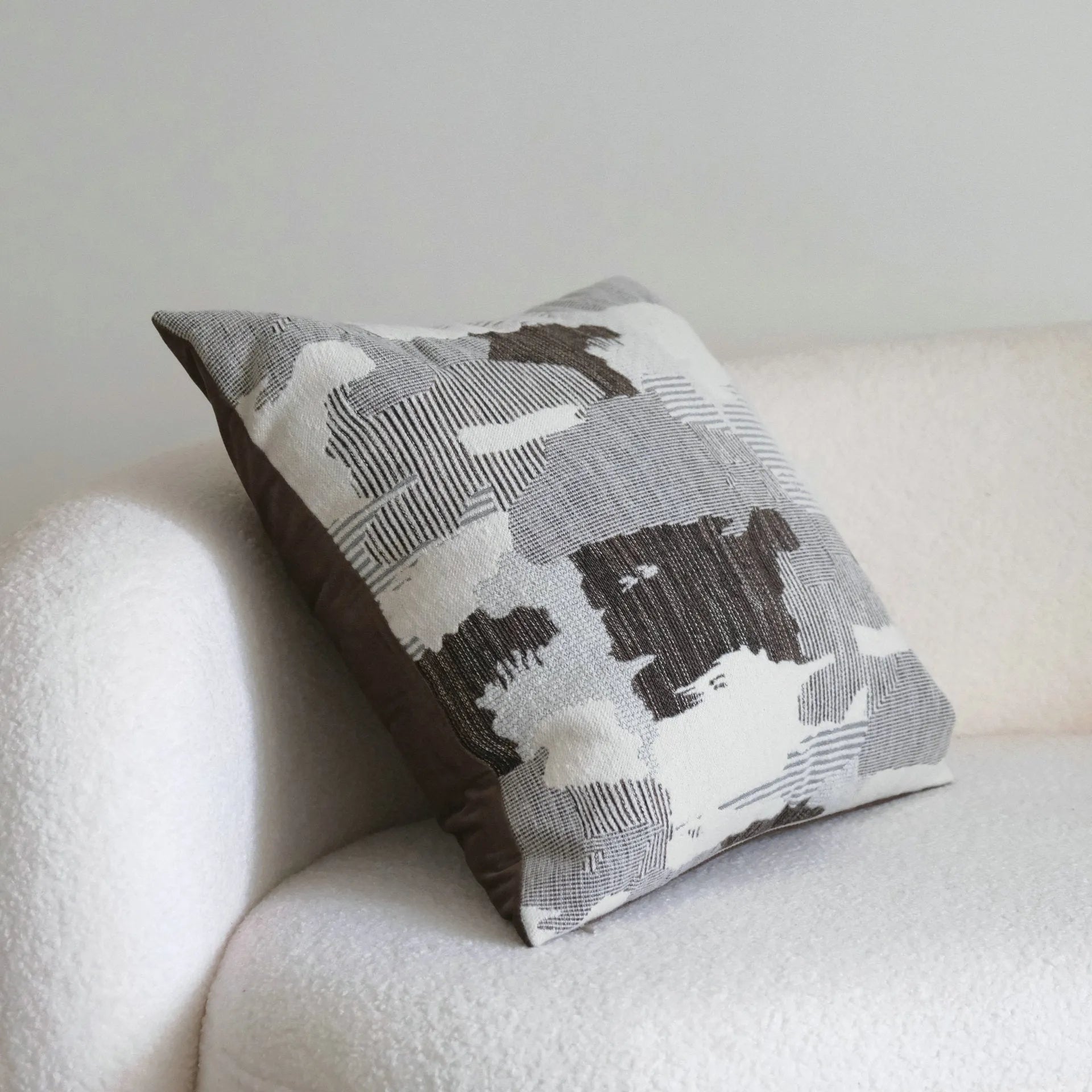 Coffee brown striped mid-century sofa cushion in Chinese classical style on a grey sofa.
