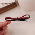 Wine red leather bow hair barrette showing handmade bow design detail