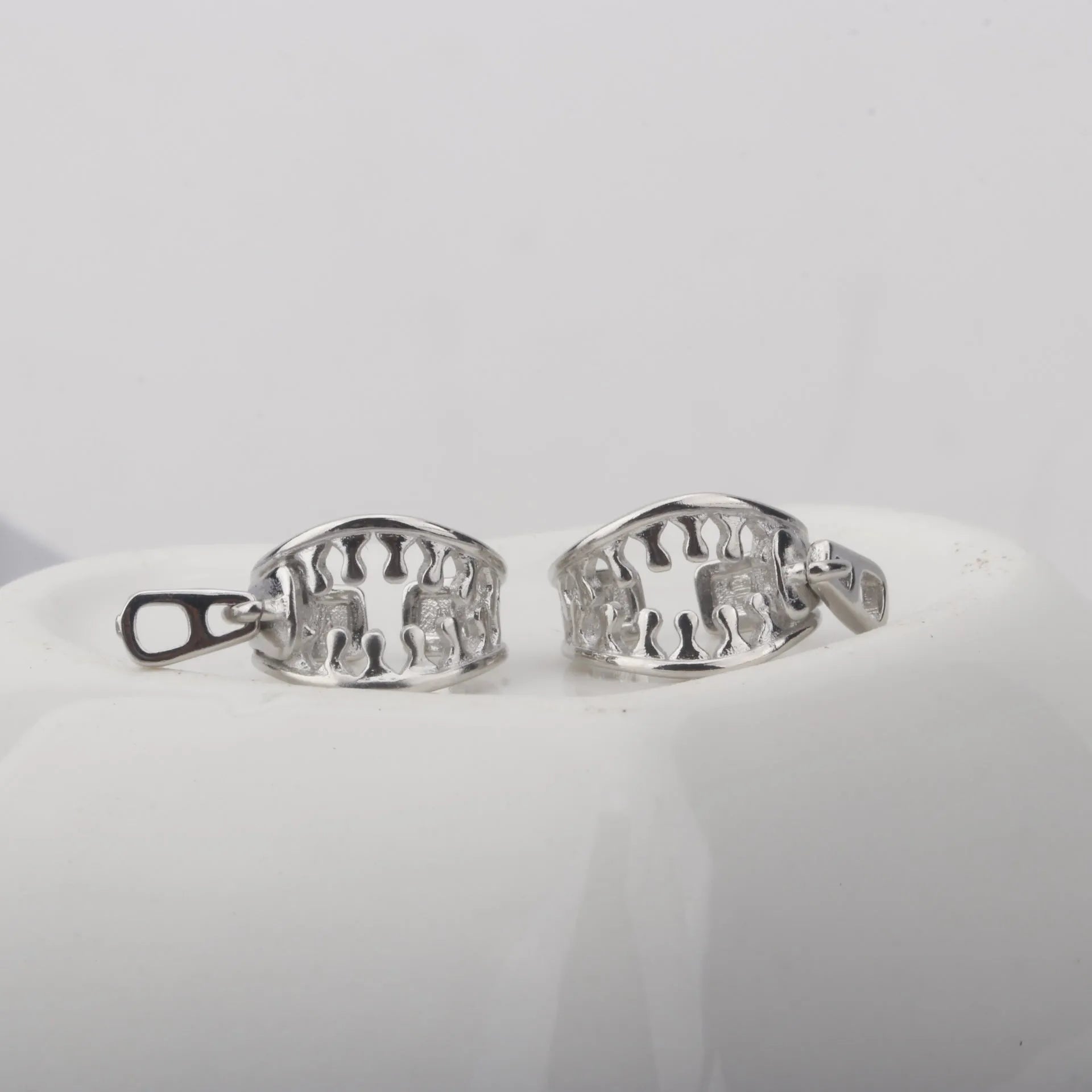 A pair of simple geometric copper clip-on earrings with a linear design on a white background.