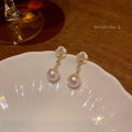 Close-up of Camellia Pearl Flower Stud Earrings for women, showing detailed floral alloy design with faux pearl centre.