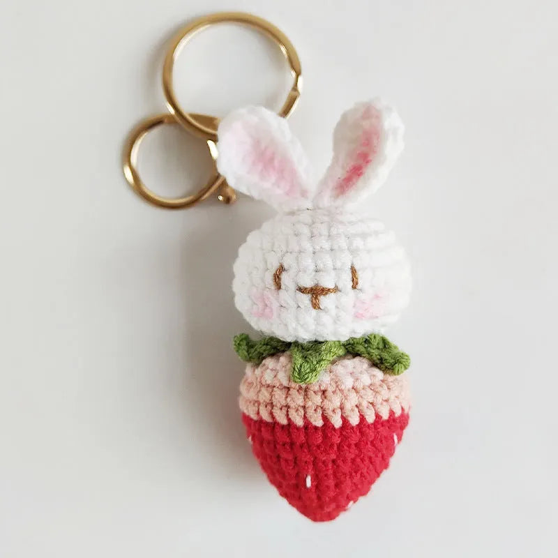 Hand-woven white wire pendant with rabbit and strawberry cartoon pattern, shown with a key attachment.