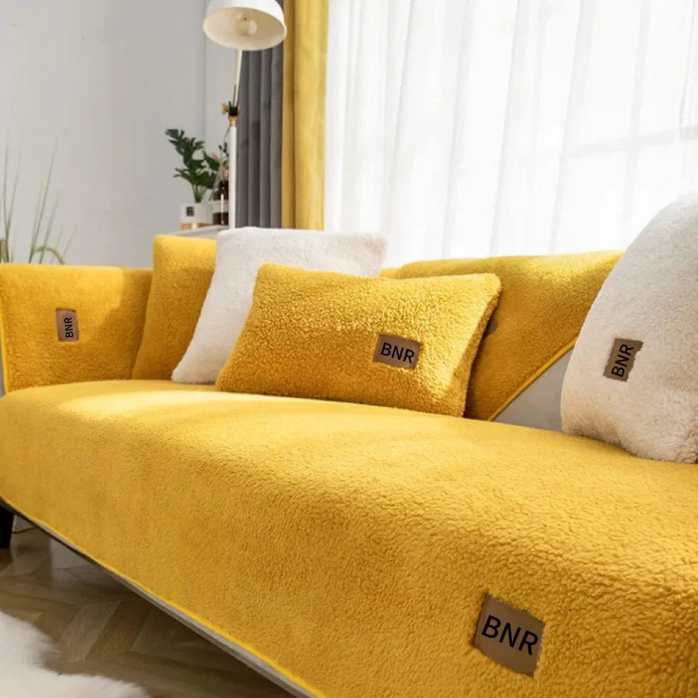 Lambswool solid colour sofa cover in blue on a grey sofa