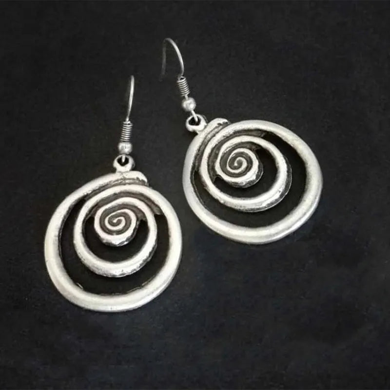 Geometric spiral distressed silver alloy drop earrings on a white background.