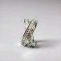 Simple metal cross ring with micro-inlaid zircon on a geometric band, shown in silver and rose gold finishes.