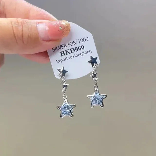 Geometric heart-shaped women's earrings with rhinestones and a silver tassel, shown on a white background.
