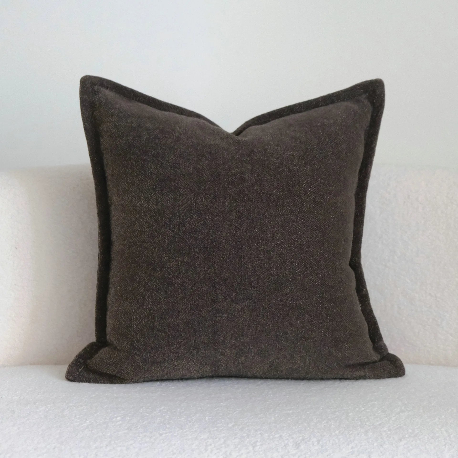 Coffee brown striped mid-century sofa cushion in Chinese classical style on a grey sofa.